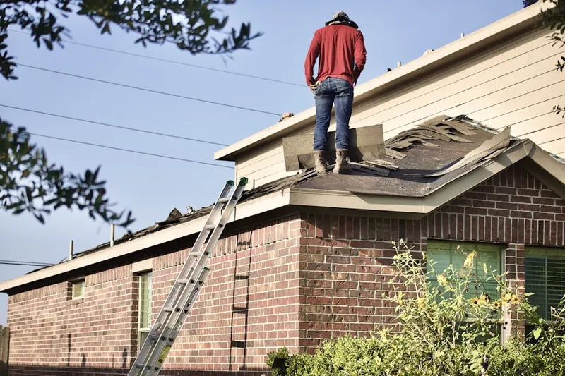 Professional roofer working on a residential roof in Windsong